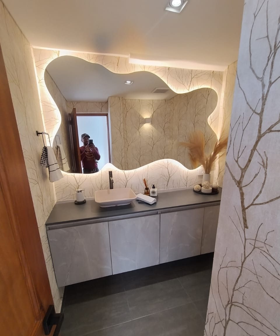 Baño con espejo de forma orgánica retroiluminado