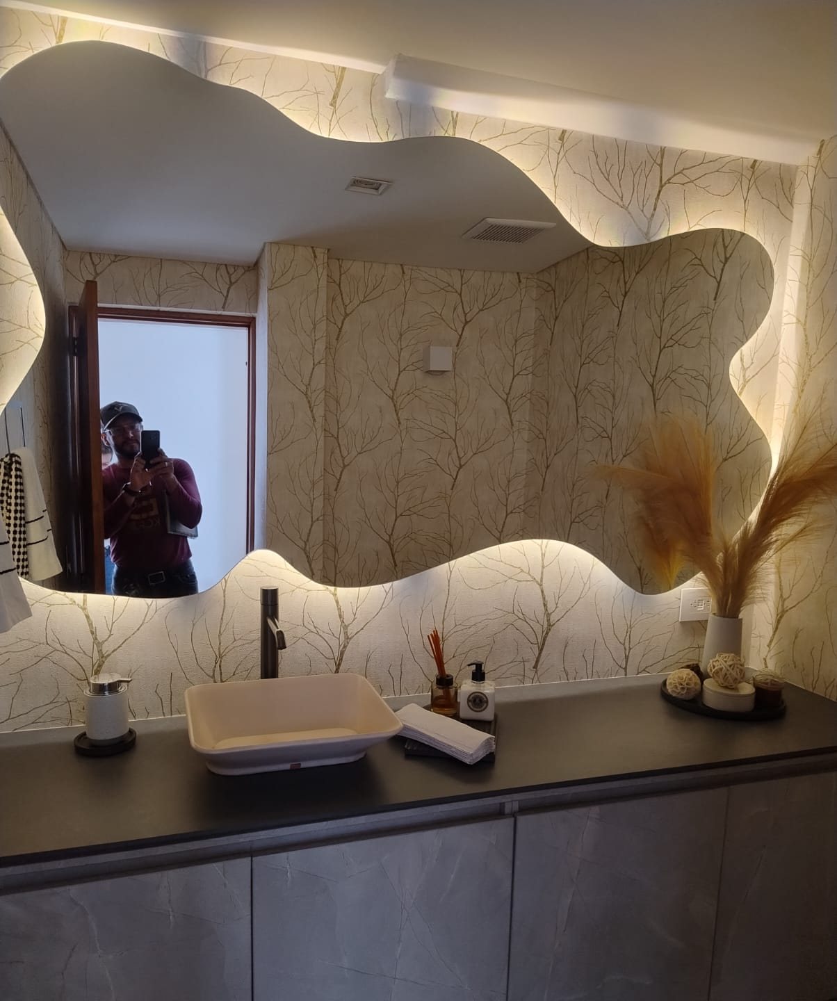 Baño con papel de colgadura y espejo retroiluminado