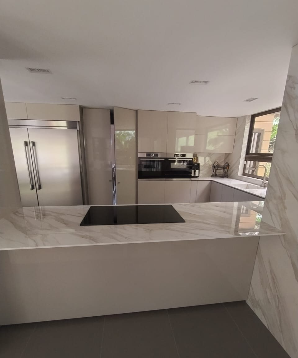 Cocina premium en tonos claros con acabados tipo mármol