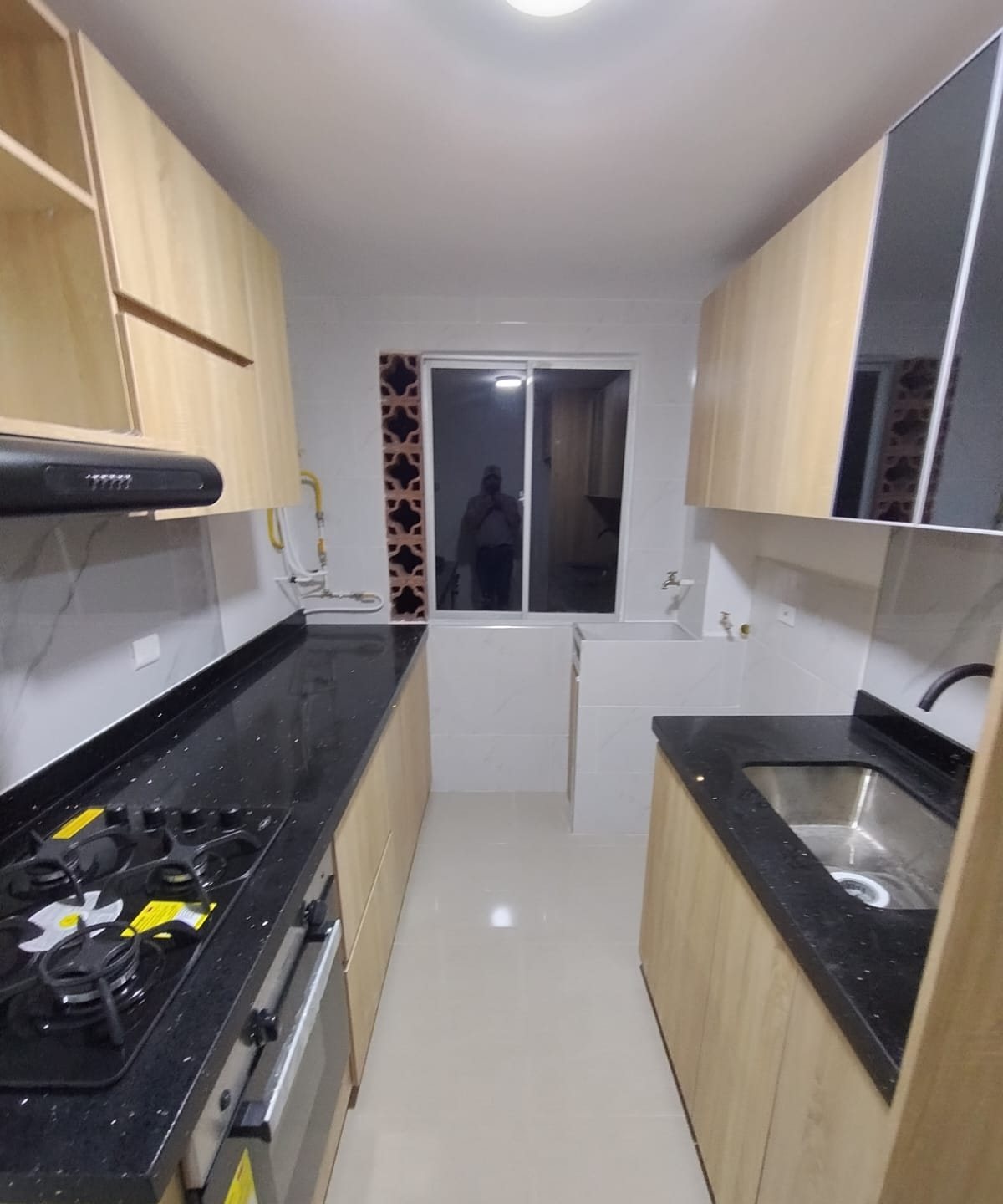 Cocina paralela con mesón en granito negro